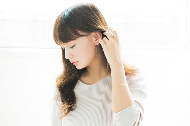 耳に髪をかきあげる女性